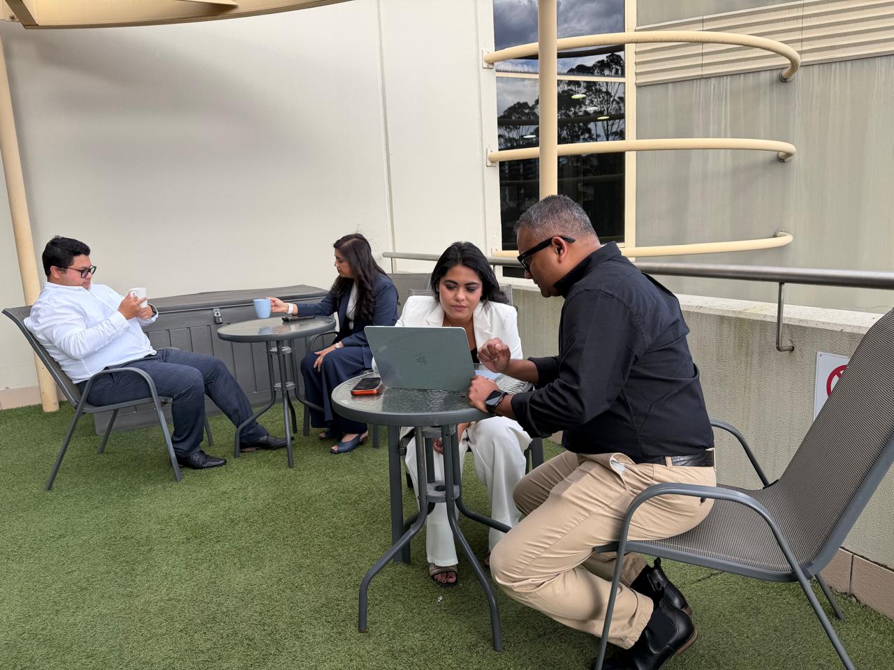 Small group discussing work around a laptop