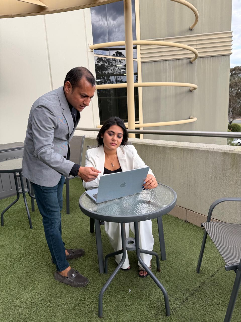 Two colleagues reviewing a laptop together